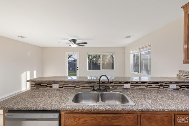 kitchen with a sink, brown cabinetry, and dishwasher