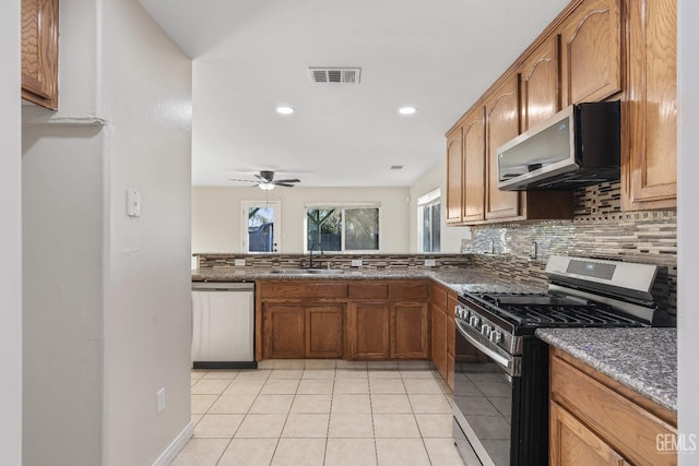 kitchen featuring light tile patterned floors, tasteful backsplash, visible vents, appliances with stainless steel finishes, and a sink