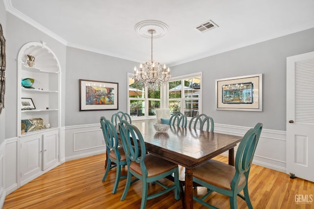 2615 22nd St, Bakersfield, CA 93301 - dining space featuring built in features, visible vents, a notable chandelier, light wood-style floors, and ornamental molding