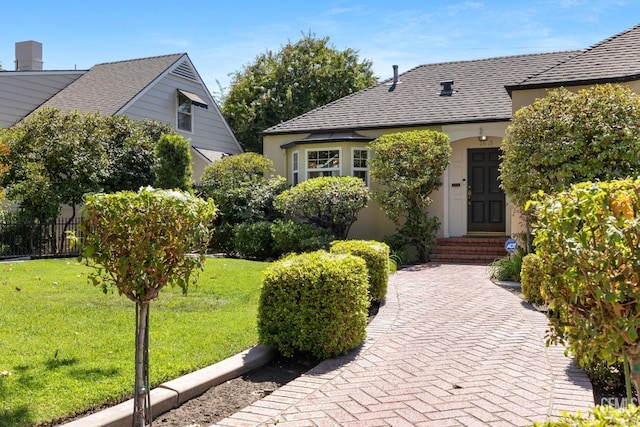 2615 22nd St, Bakersfield, CA 93301 - view of front of property with fence, a shingled roof, a front lawn, and stucco siding