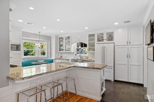 2615 22nd St, Bakersfield, CA 93301 - kitchen featuring white cabinets, high end white fridge, and crown molding