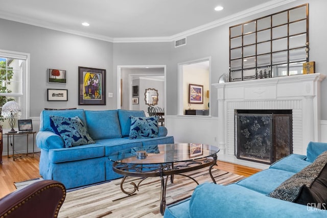 2615 22nd St, Bakersfield, CA 93301 - living room with visible vents, a brick fireplace, wood finished floors, and crown molding