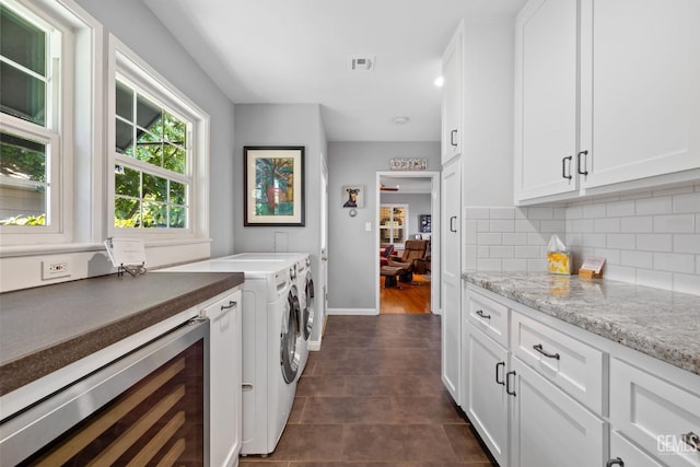 2615 22nd St, Bakersfield, CA 93301 - clothes washing area with dark tile patterned flooring, cabinet space, washing machine and dryer, wine cooler, and visible vents