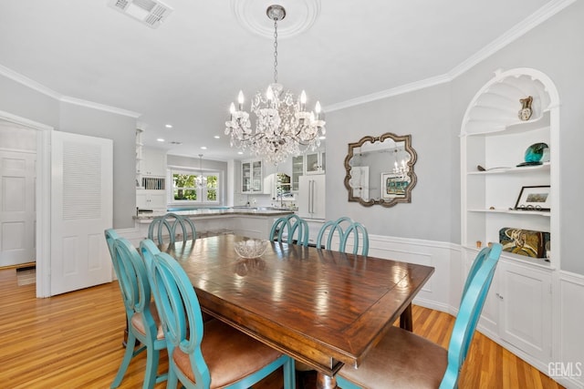 2615 22nd St, Bakersfield, CA 93301 - dining space with crown molding, light wood finished floors, a chandelier, and visible vents