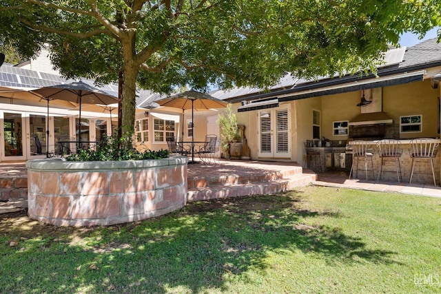 2615 22nd St, Bakersfield, CA 93301 - back of property with a yard, french doors, stucco siding, and exterior bar