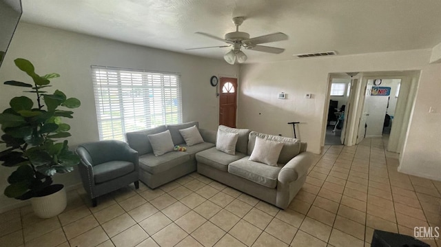 living room with ceiling fan, visible vents, and light tile patterned flooring