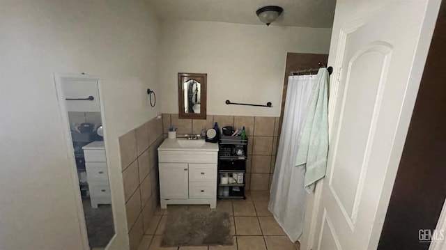 full bath with a wainscoted wall, a shower with curtain, tile walls, tile patterned flooring, and vanity