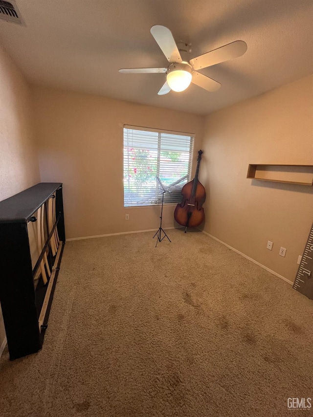 misc room featuring carpet floors, visible vents, a ceiling fan, and baseboards