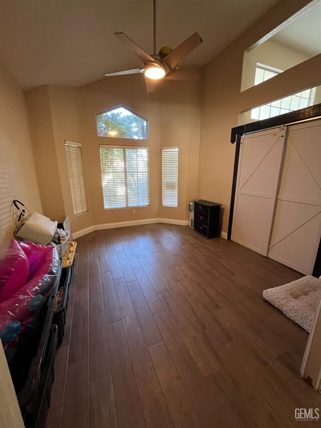 living room with high vaulted ceiling, plenty of natural light, a ceiling fan, and dark wood-style floors