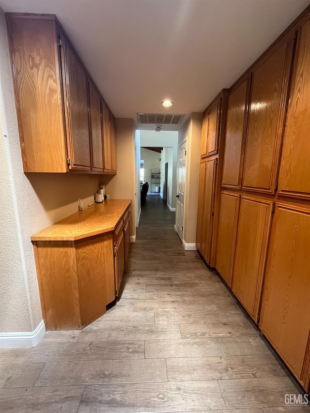 hall featuring visible vents, light wood-style flooring, baseboards, and recessed lighting