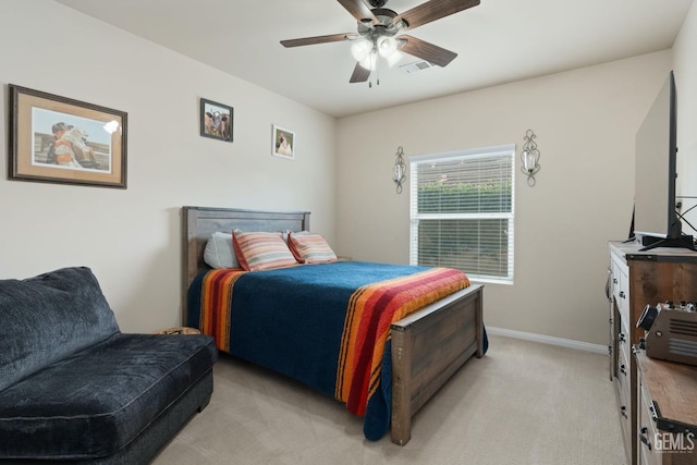 bedroom with light carpet, ceiling fan, visible vents, and baseboards