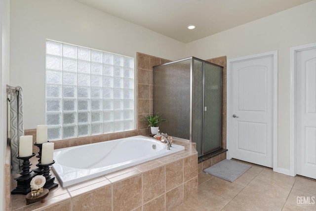 full bathroom featuring a garden tub, a shower stall, and tile patterned floors