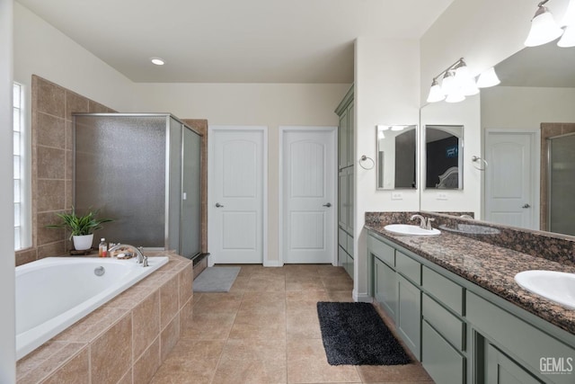 full bath featuring a garden tub, tile patterned flooring, a sink, double vanity, and a stall shower