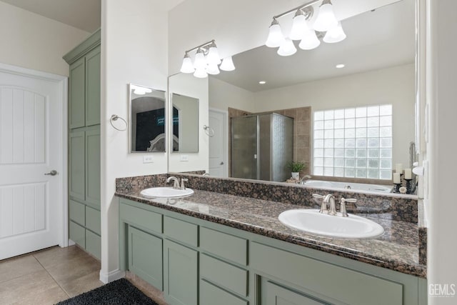 bathroom with double vanity, a shower stall, a sink, and tile patterned floors