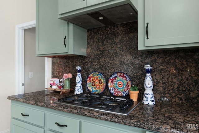 kitchen with stainless steel gas cooktop, backsplash, green cabinets, and exhaust hood