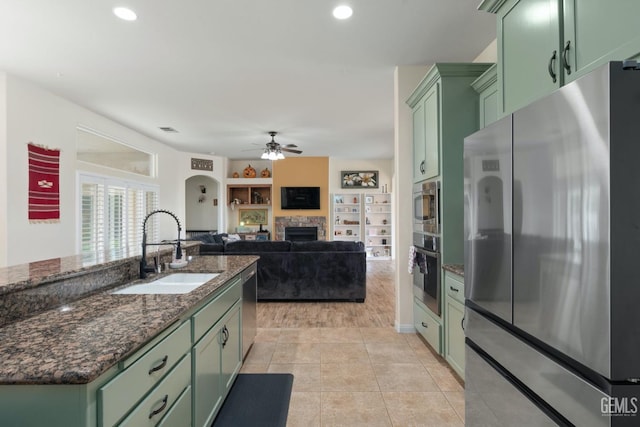 kitchen with appliances with stainless steel finishes, green cabinetry, and a sink