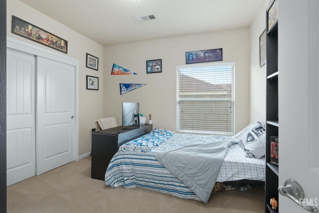 bedroom featuring a closet, visible vents, and light colored carpet