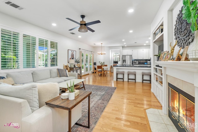 11820 Crescent Creek Ct, Bakersfield, CA 93311 - living room featuring ceiling fan, recessed lighting, light wood-type flooring, a fireplace, and a chandelier
