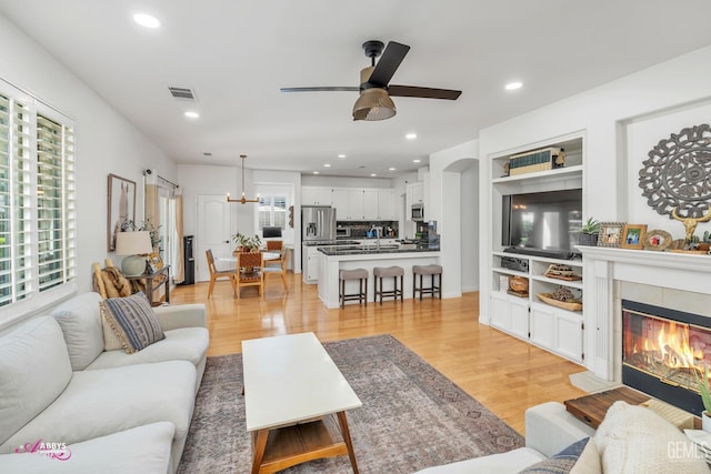 11820 Crescent Creek Ct, Bakersfield, CA 93311 - living room featuring a ceiling fan, light wood-style floors, recessed lighting, and a fireplace