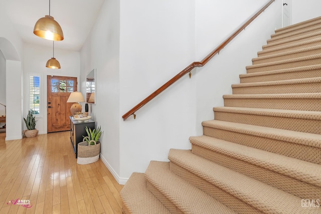 11820 Crescent Creek Ct, Bakersfield, CA 93311 - entryway featuring stairway, light wood-type flooring, high vaulted ceiling, and arched walkways