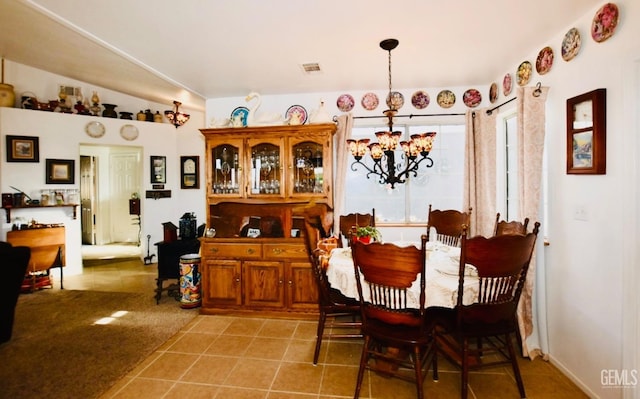 dining area featuring a chandelier, lofted ceiling, visible vents, and light tile patterned flooring