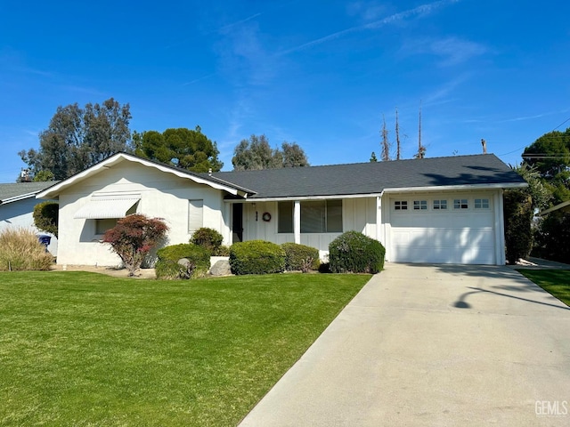 ranch-style home featuring a garage, concrete driveway, and a front lawn