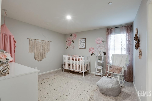 bedroom with light carpet and a nursery area