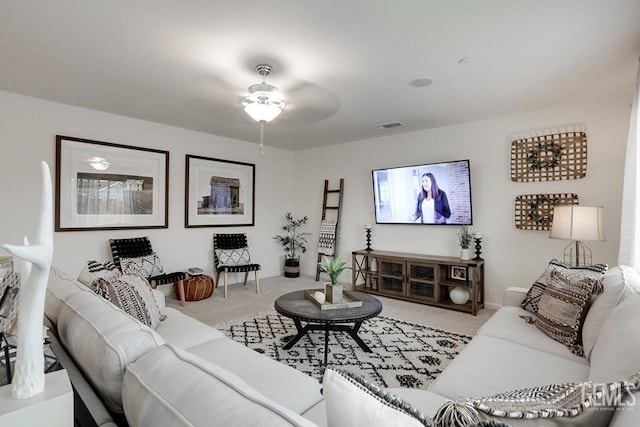 carpeted living room with ceiling fan