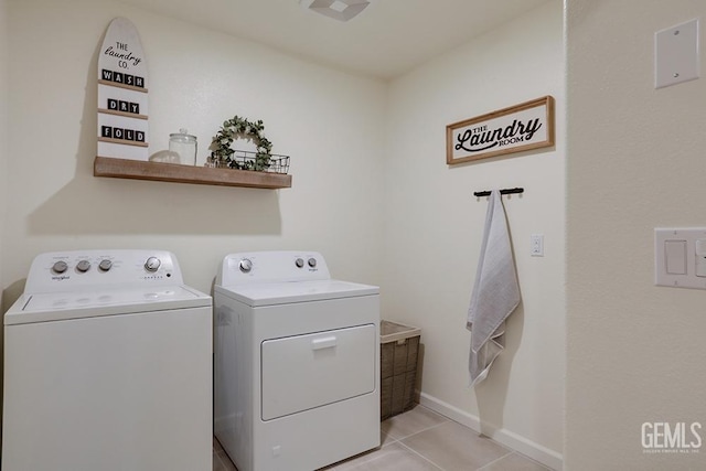 laundry area featuring separate washer and dryer and light tile patterned floors