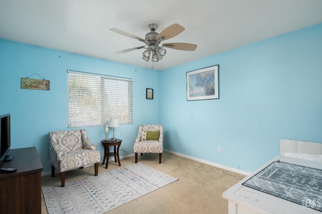 living area with light carpet and ceiling fan