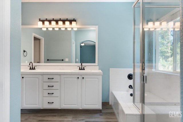 11311 Mezzadro Ave, Bakersfield, CA 93312 - full bath with double vanity, a garden tub, a ceiling fan, a shower stall, and wood finished floors