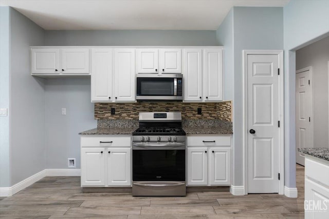 11311 Mezzadro Ave, Bakersfield, CA 93312 - kitchen featuring appliances with stainless steel finishes, dark stone countertops, light wood-style floors, and white cabinets