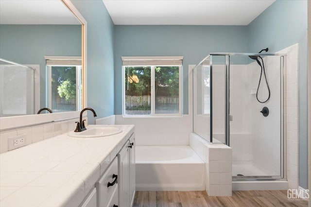 11311 Mezzadro Ave, Bakersfield, CA 93312 - full bath featuring a stall shower, vanity, wood finished floors, and a garden tub