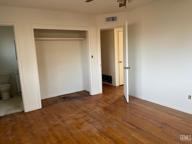 unfurnished bedroom with connected bathroom, hardwood / wood-style floors, and a closet