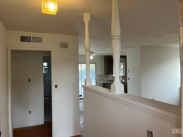 hallway featuring dark hardwood / wood-style flooring and ornate columns