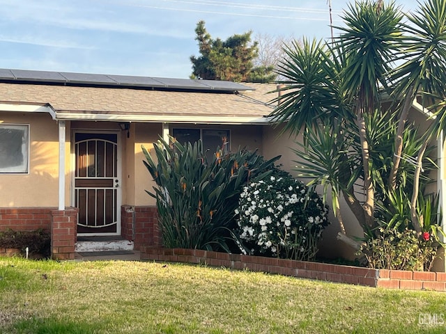 doorway to property featuring a yard and solar panels