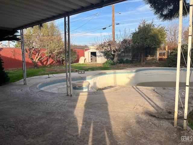 view of swimming pool featuring a storage shed and a jacuzzi