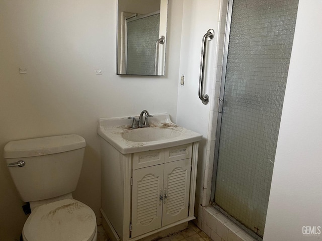 bathroom with vanity, a shower with door, and toilet