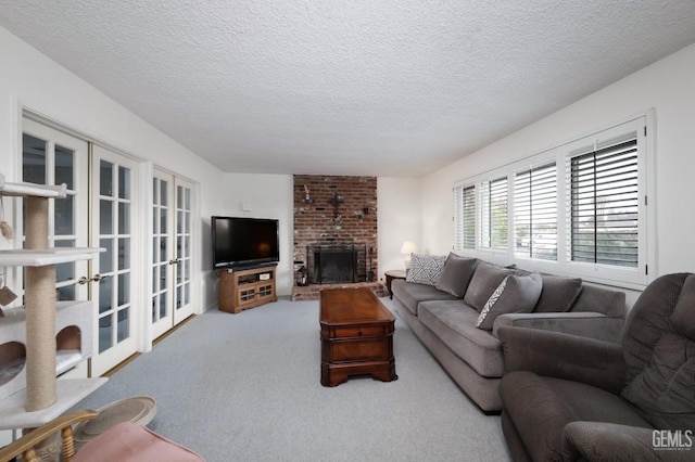 carpeted living room with french doors, a textured ceiling, and a brick fireplace