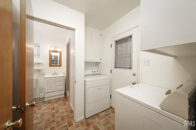 laundry room featuring washer and clothes dryer, cabinets, and sink