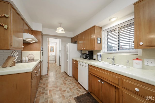 kitchen featuring decorative backsplash, white appliances, tile counters, and sink