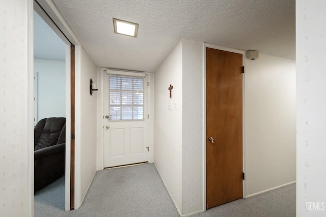 entryway featuring a textured ceiling and light carpet