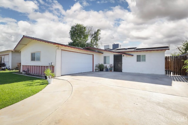 705 Stephens Dr, Bakersfield, CA 93304 - view of front facade with stucco siding, a garage, solar panels, and driveway