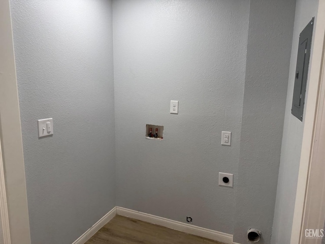 laundry area with wood-type flooring, hookup for an electric dryer, hookup for a washing machine, and electric panel