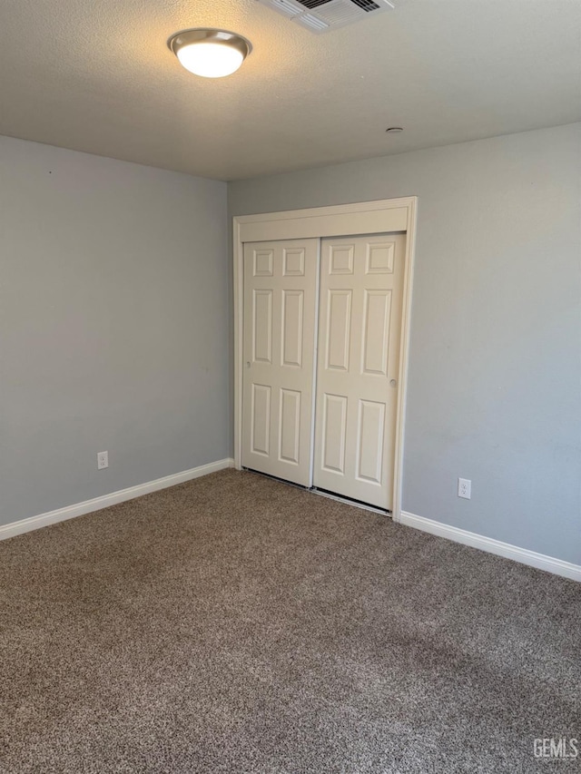 unfurnished bedroom featuring carpet floors and a closet