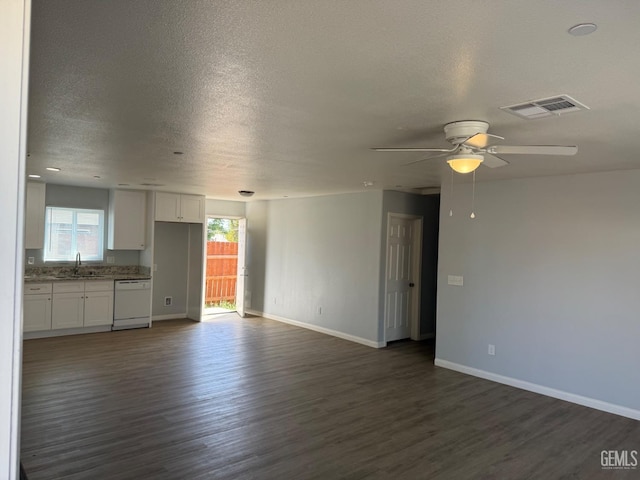 unfurnished living room with ceiling fan, dark wood-type flooring, sink, and a textured ceiling