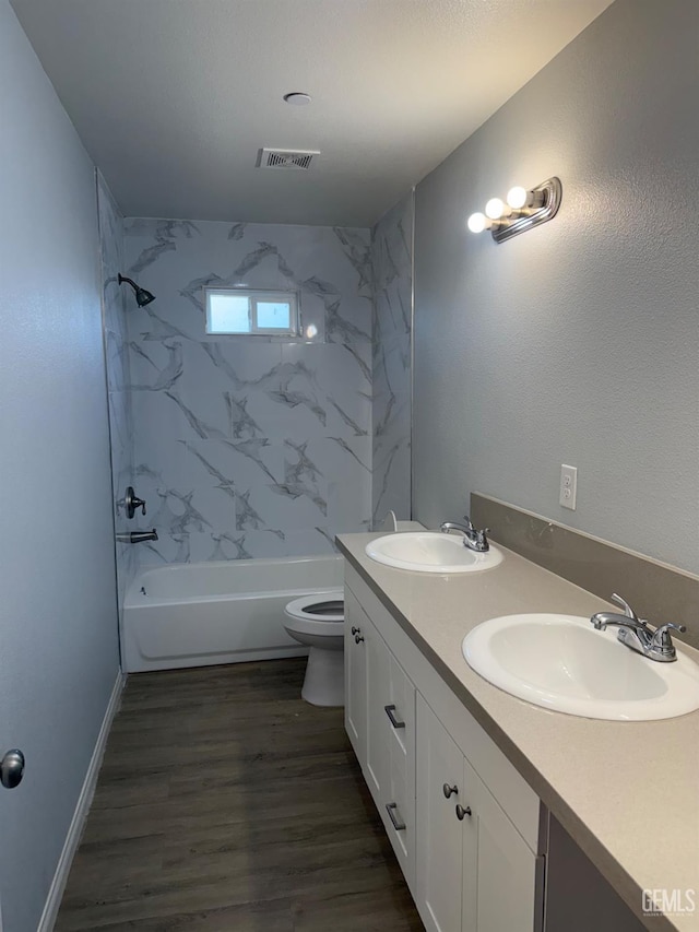 full bathroom featuring toilet, tiled shower / bath, hardwood / wood-style floors, and vanity