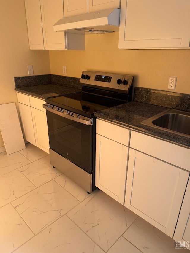 kitchen featuring electric stove, white cabinetry, sink, and dark stone countertops