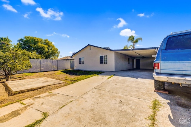 view of side of property featuring a lawn and a carport