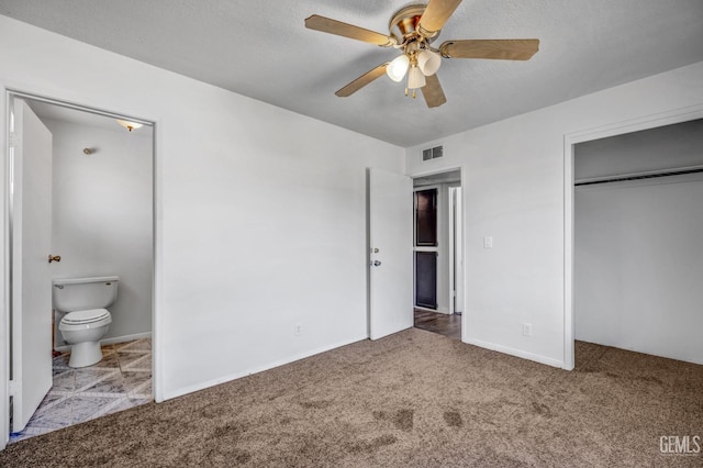 unfurnished bedroom with ceiling fan, ensuite bath, light carpet, and a closet